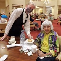The Carriage House Gracious Retirement Living Hawthorn Senior Independent Living in Oxford, Florida resident being served a meal by a staff member