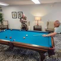 Desert Springs Gracious Retirement Living Hawthorn Senior Independent Living in Oro Valley, Arizona resident playing pool at a billiards table