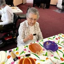 Stoneybrook Lodge Gracious Retirement Living Hawthorn Senior Independent Living in Corvallis, Oregon resident painting a pumpkin