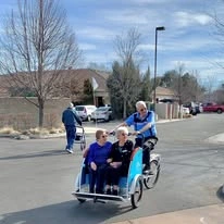 Salmon Creek Gracious Retirement Living Hawthorn Senior Independent Living in Boise, Idaho resident riding a bicycle and pushing other residents