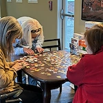 American House Elmwood, senior living community offering independent living, assisted living, memory care, and respite care in Rochester Hills, MI, residents working together to solve a puzzle