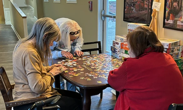 American House Elmwood, senior living community offering independent living, assisted living, memory care, and respite care in Rochester Hills, MI, residents working together to solve a puzzle