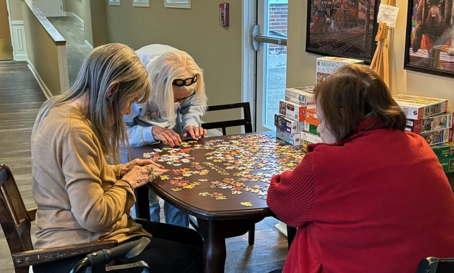 American House Elmwood, senior living community offering independent living, assisted living, memory care, and respite care in Rochester Hills, MI, residents working together to solve a puzzle
