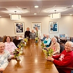 KindCare at Bristol, CT, residents smile with floral creations from activity