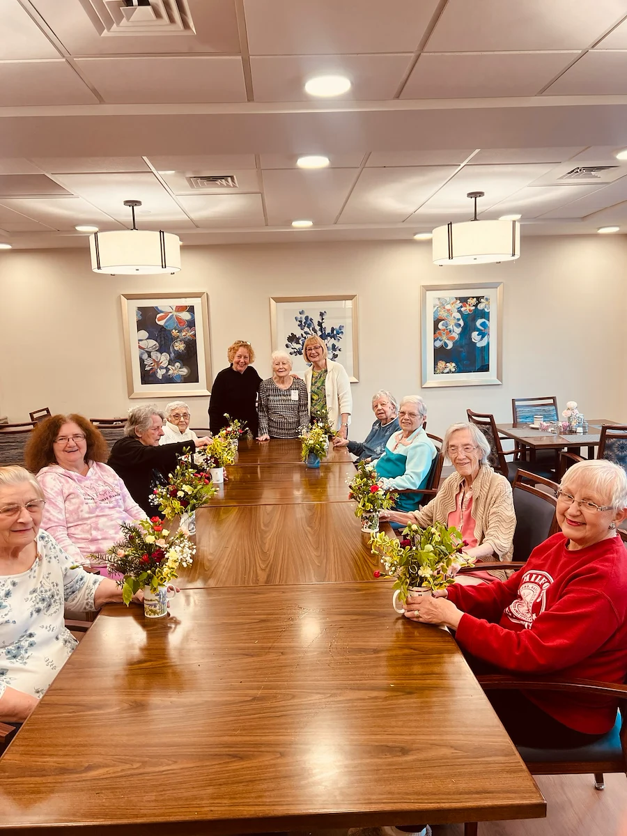 KindCare at Bristol, CT, residents smile with floral creations from activity