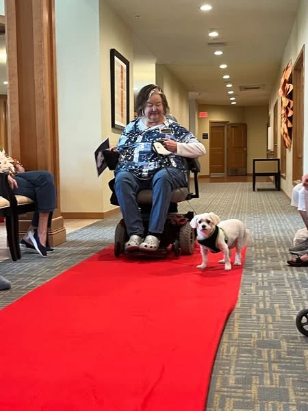 One of the Waters of Plymouth residents interact with one of the dogs from the dog parade
