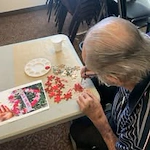 Stone Lodge Gracious Retirement Living Hawthorn Senior independent Living in Bend, Oregon resident solving a puzzle