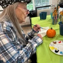 The Oaks At Lebanon Senior Living Community in Lebanon, Oregon resident painting a pumpkin