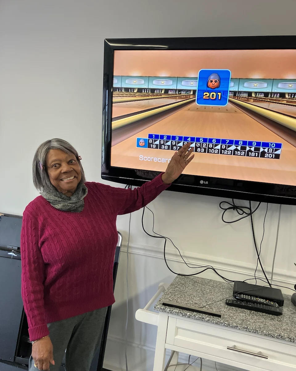 American House Farmington Hills, senior living community offering independent living, assisted living, memory care, and respite care in Farmington Hills, MI, resident having fun playing Wii Bowling