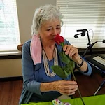 The Carriage House Gracious Retirement Living Hawthorn Senior Independent Living in Oxford, Florida resident smelling a rose