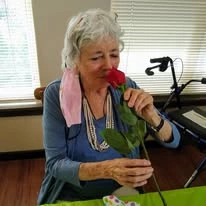 The Carriage House Gracious Retirement Living Hawthorn Senior Independent Living in Oxford, Florida resident smelling a rose