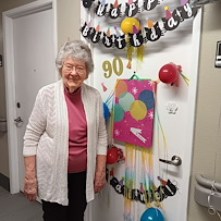 Heatherwood Senior Living resident smiles with birthday decorations