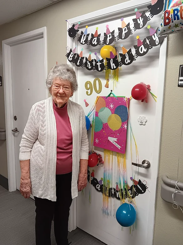Heatherwood Senior Living resident smiles with birthday decorations