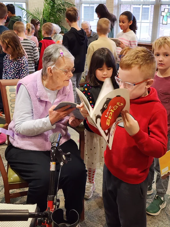 Allisonville Meadows Assisted Living offering assisted living, memory care, and respite care in Fishers, IN, residents reading with children