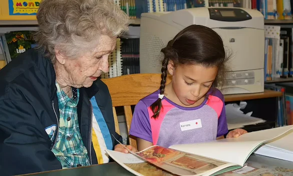 Willowbrook Place Senior Assisted Living Memory Care in Littleton, CO resident reading a book with a child