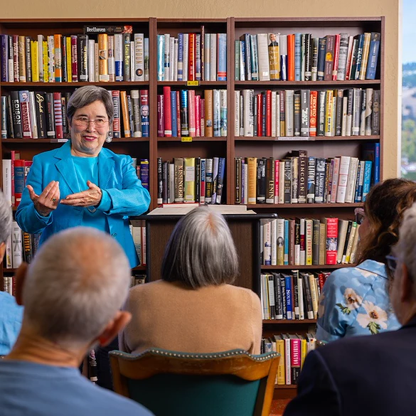 Piedmont Gardens Senior Living in Oakland, CA, residents engaged in a presentation in the library