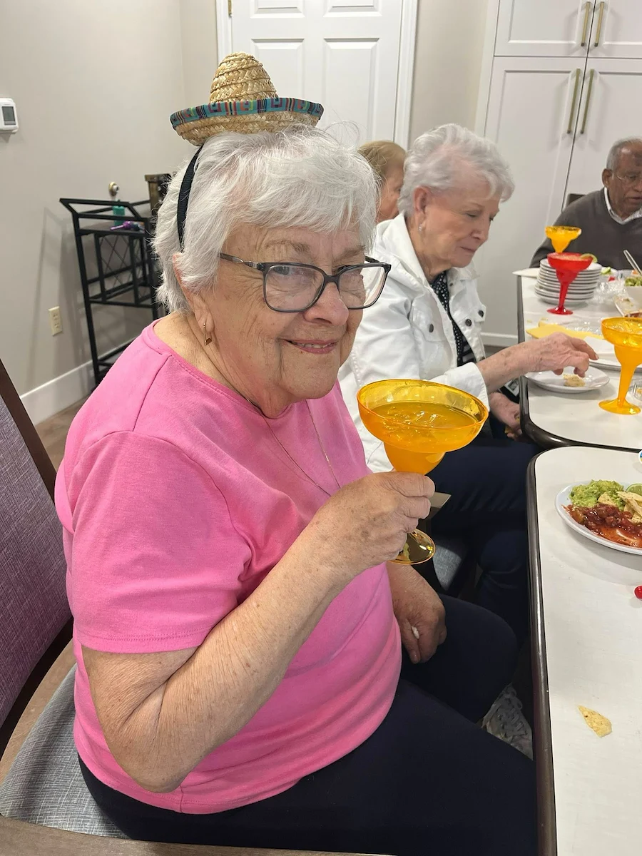 Charter Senior Living of Dedham in Dedham, MA, resident enjoying a drink and good company
