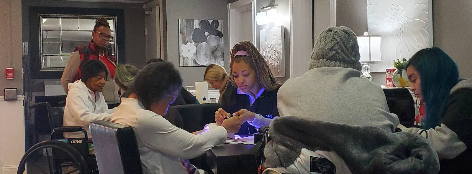 American House Westland Venoy senior living community offering independent living, assisted living, and respite care in Westland, MI, resident getting her nails done by a staff member
