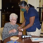 The Oaks Gracious Retirement Living Hawthorn Senior Independent Living in Georgetown, Texas resident being helped by a staff member