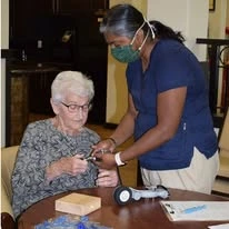 The Oaks Gracious Retirement Living Hawthorn Senior Independent Living in Georgetown, Texas resident being helped by a staff member