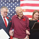 Chelsea Place Memory Care resident standing in front of an American flag