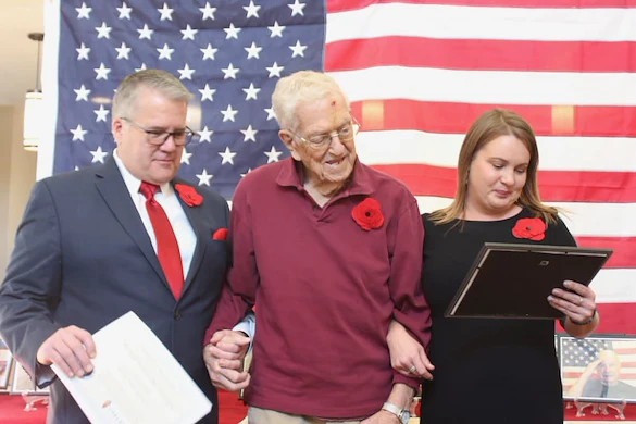 Chelsea Place Memory Care resident standing in front of an American flag