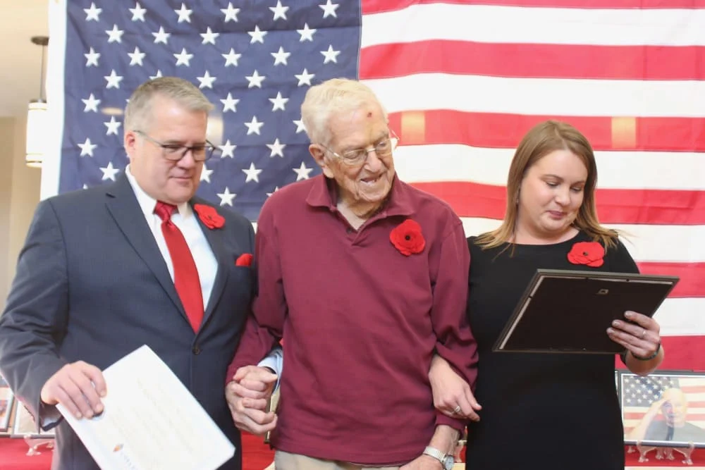 Chelsea Place Memory Care resident standing in front of an American flag