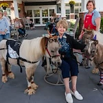 The Savoy Gracious Retirement Living Hawthorn Senior Independent Living in Winter Springs, Florida residents petting two ponies