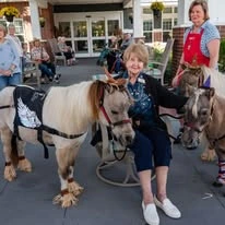 The Savoy Gracious Retirement Living Hawthorn Senior Independent Living in Winter Springs, Florida residents petting two ponies