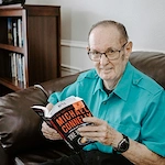Resident reading beside bookshelf
