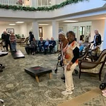 The Lodge at Wake Forest Gracious Retirement Living Hawthorn Senior Independent Living in Wake Forest, North Carolina residents playing a game of cornhole bean bags