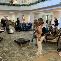 The Lodge at Wake Forest Gracious Retirement Living Hawthorn Senior Independent Living in Wake Forest, North Carolina residents playing a game of cornhole bean bags