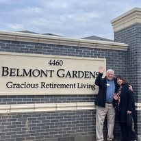 Belmont Gardens Gracious Retirement Living Hawthorn Senior Independent Living in Woodbridge, Virginia resident in front of the front entrance welcome sign