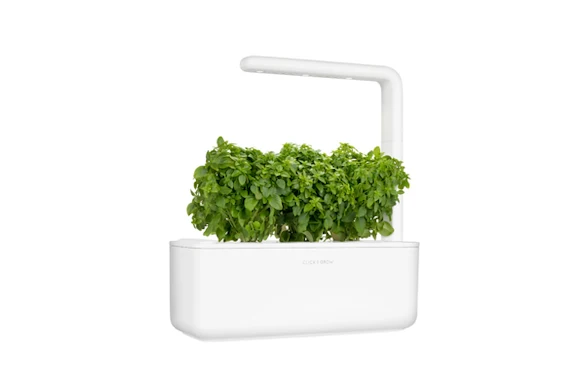 electronic gardening kit with herbs growing from it