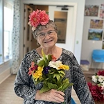 The Barclay at Little River smiling resident with floral creation