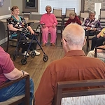 American House Westland Venoy senior living community offering independent living, assisted living, and respite care in Westland, MI, residents sitting in a circle and chatting