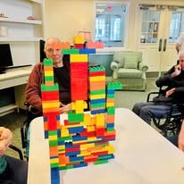 senior showing off lego tower at Serenades at Longwood