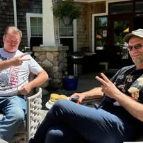 Avamere at Seaside senior living community offering independent living, assisted living, memory care, and respite care in Seaside, OR, residents holding a "peace" sign while enjoying time outdoors