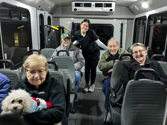 Seniors at Charter Senior Living of Hasmer Lake in Jackson, WI, riding together on a community van, enjoying group transportation for outings and social activities.
