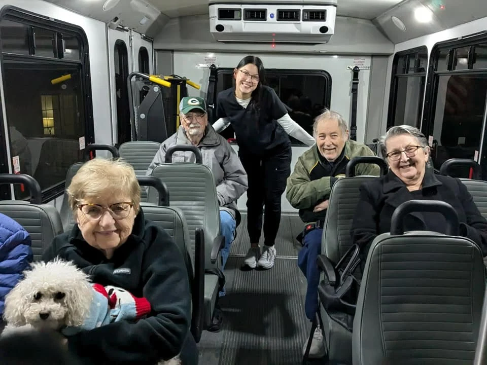 Seniors at Charter Senior Living of Hasmer Lake in Jackson, WI, riding together on a community van, enjoying group transportation for outings and social activities.