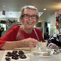 Chateau Valley Center in Renton, WA, smiling resident while making a fun treat