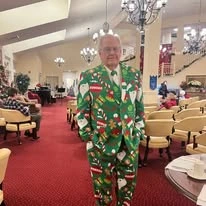 Fairview Estates Gracious Retirement Living Hawthorn Senior Independent Living in Hopkinton, Massachusetts resident in a Christmas themed suit