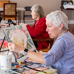 Piedmont Gardens Senior Living in Oakland, CA, resident enjoying an activity - painting