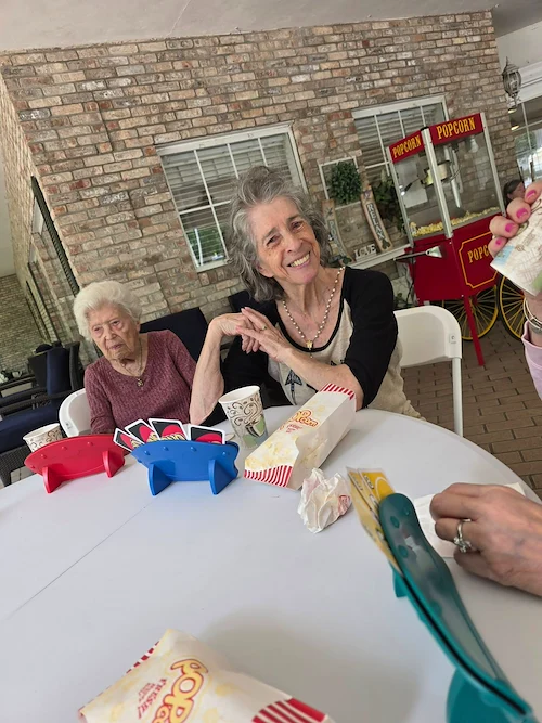 Charter Senior Living of Gainesville, Florida, residents enjoying playing cards together outside
