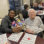 American House Stone senior living community offering independent living and respite care in Rochester Hills, MI, resident receiving a prize after winning Bingo