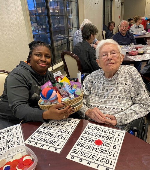 American House Stone Independent Senior Living in Rochester Hills, MI resident winning Bingo and receiving gift basket from staff