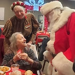 American House Westland Venoy senior living community offering independent living, assisted living, and respite care in Westland, MI, resident interacting with Santa Clause at Christmas time