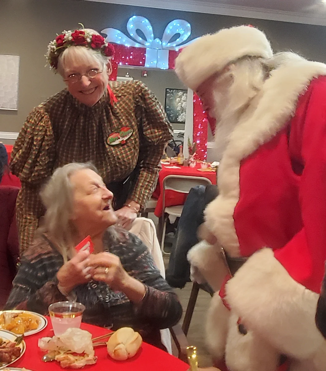American House Westland Venoy senior living community offering independent living, assisted living, and respite care in Westland, MI, resident interacting with Santa Clause at Christmas time