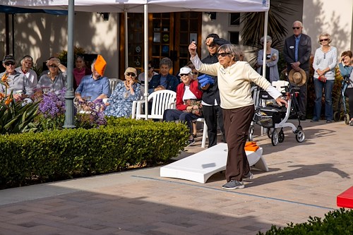 Covenant Living at the Samarkand in Santa Barbara, CA, resident enjoying an outdoor activity - cornhole
