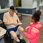 Charter Senior Living of Bowie resident enjoys a visitor and special note
